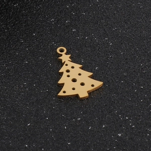 Dettaglio del ciondolo a forma di albero di Natale dorato su superficie scura