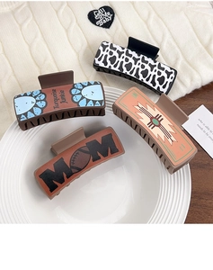 Macro view of four western-style claw clips featuring cow print and retro patterns