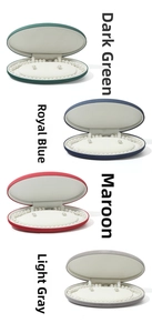 Detailed view of oval velvet jewelry boxes in green, blue, red and grey for pearls