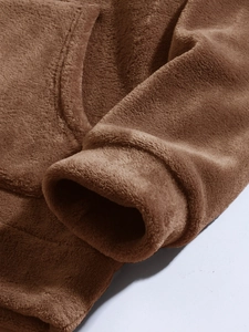 Detail of soft brown coral fleece fabric on hoodie sleeve and functional pocket area