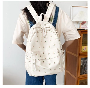 Detailed close-up of cream floral backpack featuring pink flower patterns and white drawstrings