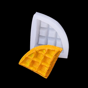 White silicone waffle mold with realistic yellow dessert cake model on black background