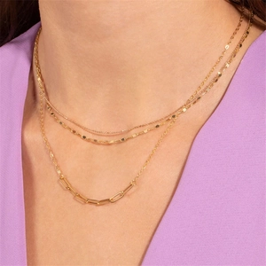 Close-up of layered gold S925 silver necklaces with paperclip chain on model