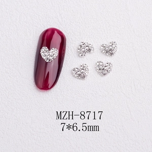 Detailed view of silver heart nail art rhinestones with dimensions and application on red nail