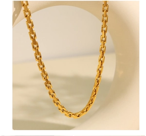Close-up of golden geometric link chain necklace with high-quality 18K gold texture