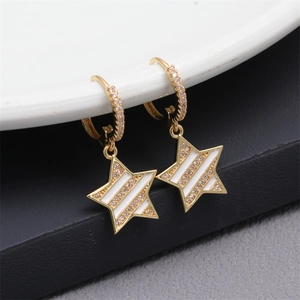 Detail of star-shaped drop earrings featuring white enamel and cubic zirconia stones