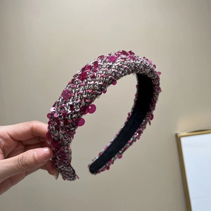 Close-up of tweed padded headband featuring pink sequins and thick braided texture