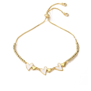Dettaglio di bracciale regolabile in oro con cuori in smalto bianco e perle di cristallo