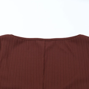 Vue macro détaillée de la texture du tricot côtelé marron foncé et de la couture