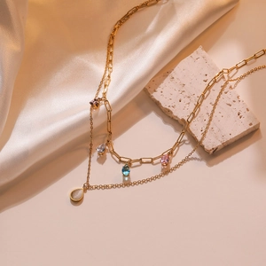 Double-layered gold necklace with colorful teardrop stones and devil's eye pendant