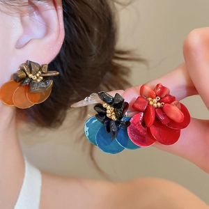 Close-up of vintage resin earrings with tiger eye stone and shell flower design