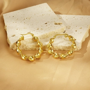 18K gold plated twisted hoop earrings with sparkling crystals on silk background