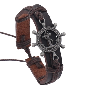 Detail showing multi-layer brown leather braid with silver anchor and rudder charms