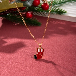 Detailed close-up of a golden Christmas stocking pendant with snow patterns on red texture