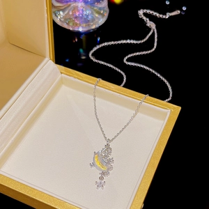 Silver star and moon pendant necklace with zircon in a gold jewelry box on black