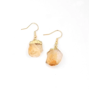 Natural yellow raw stone earrings with gold hooks on a minimalist white background