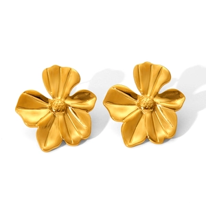 Detail view of gold flower earrings showing radial brushed texture and raised center detail