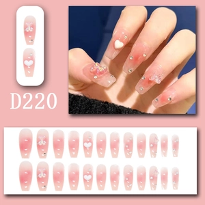 Pink gradient press-on nails featuring 3D bows, hearts, and glittering rhinestones