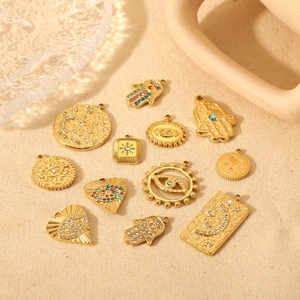 Dettaglio di ciondoli Mano di Fatima e Malocchio placcati in oro 18K con zirconi