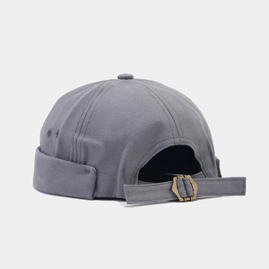Detail of gray canvas docker hat featuring an adjustable metal buckle and retro strap back