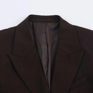Détail des revers en pointe et du décolleté d'une veste de tailleur croisée marron chocolat