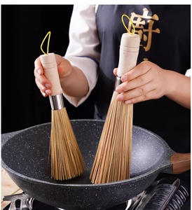 Close-up of dual natural bamboo brushes with ergonomic wood handles and hanging ropes