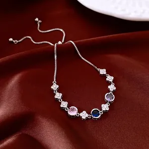 Adjustable silver bracelet with cubic zirconia clovers and colorful gemstones on silk