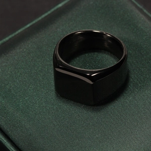 Polished black stainless steel square signet ring for men on premium textured display