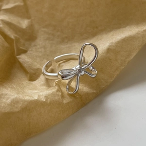Elegant 925 sterling silver bow ring with adjustable opening on textured background