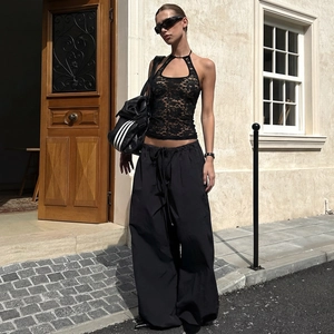 Haut licou en dentelle noire chic associé à un pantalon cargo dans un cadre extérieur