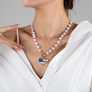 Detail of lavender pearl necklace with a rhinestone heart American flag charm on model