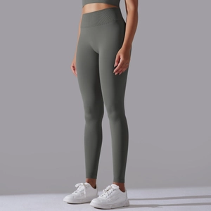 Detailed side view of high-waisted seamless yoga leggings and bra in olive green fabric