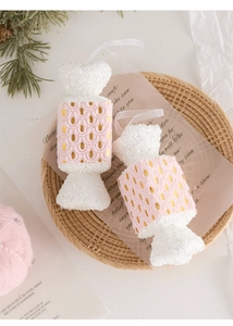 Close-up of pink glitter candy-shaped Christmas tree ornaments on a woven tray