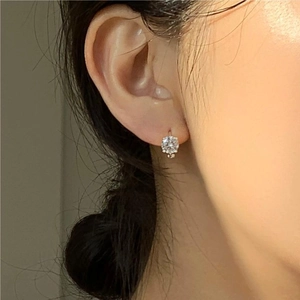 Classic 925 sterling silver four-claw stud earrings with sparkling cubic zirconia on ear