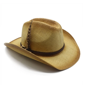 Détail d'un chapeau de cowboy en paille tressé avec ruban brun et plume décorative