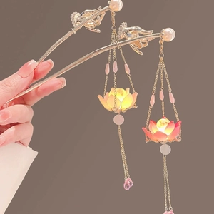 Close-up of glowing lotus lantern hair pin with golden tassels and delicate pearls