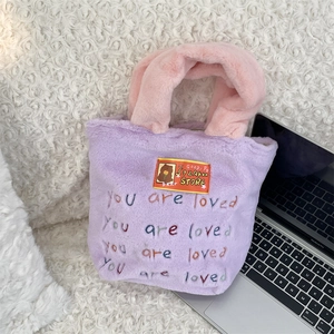 Détail d'un sac cabas en peluche violette avec broderie colorée You are loved