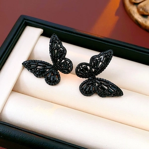 Macro view of black hollow butterfly studs with densely set cubic zirconia stones