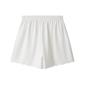 Detail of white elastic waist shorts with wavy hem and silky drape texture