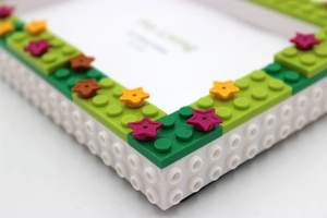 Close-up of DIY building block photo frame with colorful stars and green accents