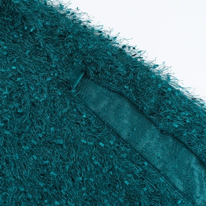 Macro detail of dark teal faux fur knit fabric showing feather yarn texture and seam work
