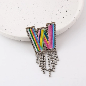 Detail of W-shaped brooch with colorful embroidery, rhinestones and elegant long tassels