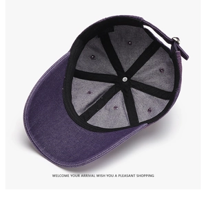 Detail of washed purple cotton baseball cap showing internal seams and metal buckle