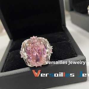 Macro shot of large pink oval gemstone ring with 18k plating and side crystal details