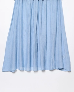 Gros plan sur la texture plissée bleu clair d'une jupe mi-longue pour femme