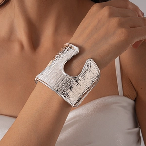 Detailed macro view of silver hammered texture cuff bracelet with irregular U-shaped cutout