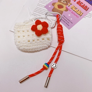 Vue détaillée de la coque AirPods blanche au crochet avec fleur rouge et lanière tissée