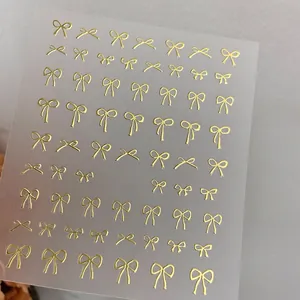 Detailed close-up of metallic gold bowknot nail stickers with embossed 3D relief texture