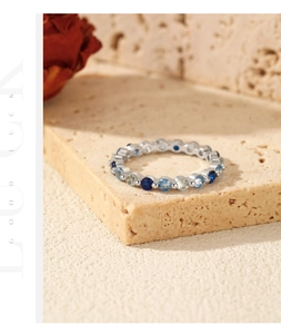Detail of S925 silver ring with blue gradient pavé diamonds on a beige stone base