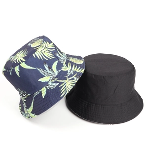 Detail of cotton bucket hat with tropical pineapple print and solid black reversible side